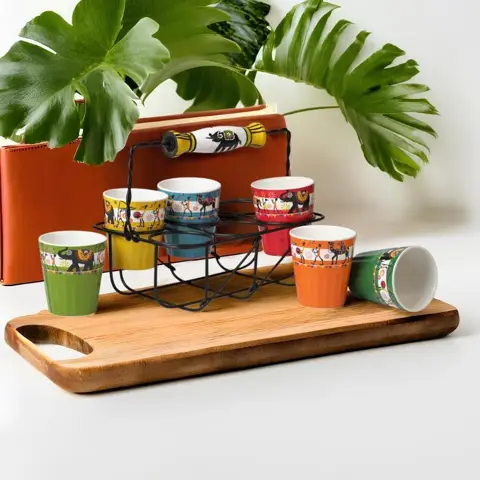 Colourful SOMNY ceramic tumblers displayed on a metal stand